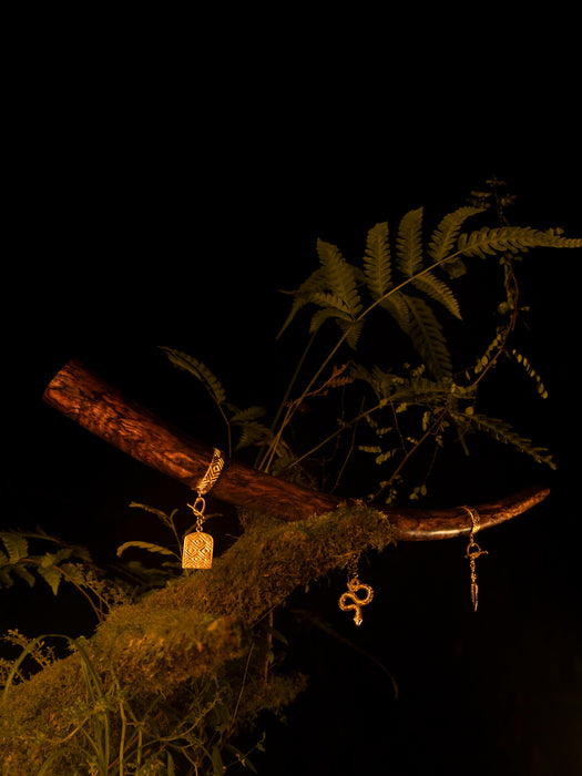 Three keys hanging from a branch with green leaves against a dark background