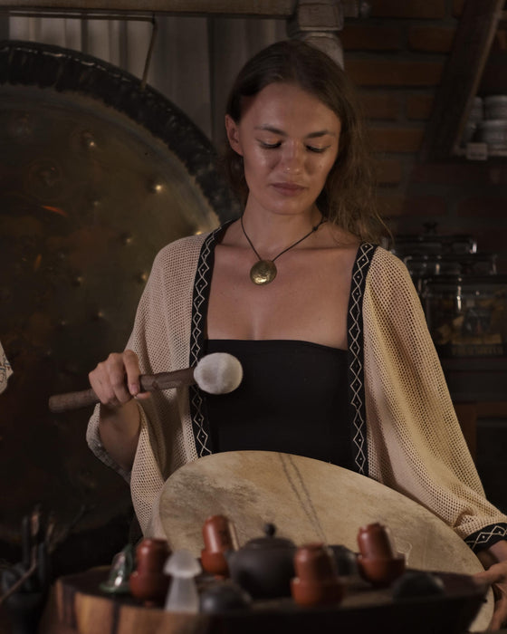 Woman playing a gong in a traditional setting