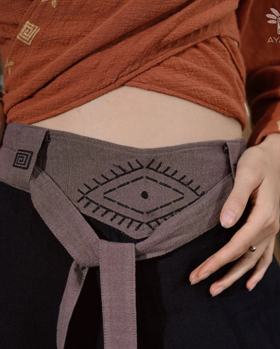 Close-up of unisex cotton pants featuring a white hand-embroidered tribal pattern, embodying Boho and shamanic styles