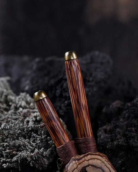 A hand presents a wooden kuripe pipe, meticulously handcrafted for hape snuff application This unique smoking accessory, with its necklace design and rustic charm, exemplifies traditional shamanic tools and doubles as a protective herbal medicine kit