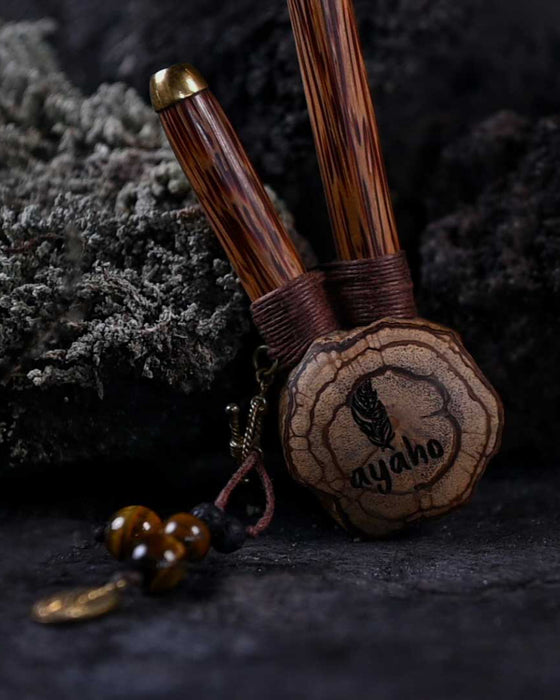 A hand presents a wooden kuripe pipe, meticulously handcrafted for hape snuff application This unique smoking accessory, with its necklace design and rustic charm, exemplifies traditional shamanic tools and doubles as a protective herbal medicine kit