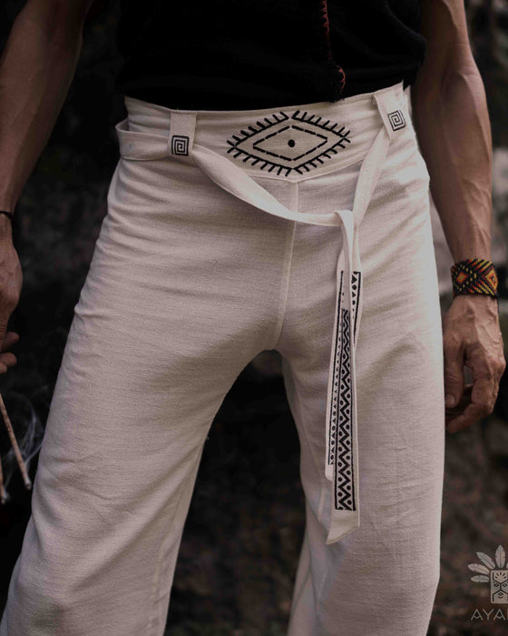 Close-up of unisex linen pants featuring a white hand-embroidered tribal pattern, embodying Boho and shamanic styles