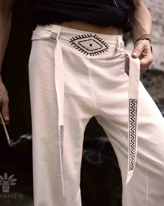Close-up of unisex linen pants featuring a white hand-embroidered tribal pattern, embodying Boho and shamanic styles
