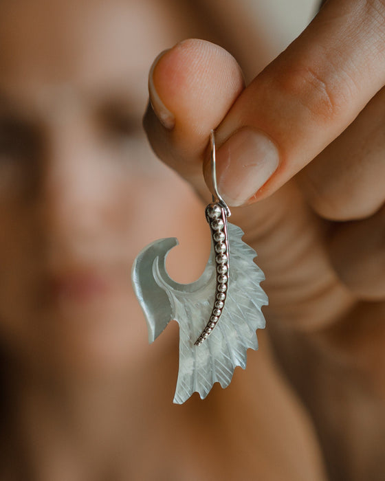 Exquisite Angel Wings earrings, crafted from lustrous mother-of-pearl and detailed sterling silver, radiating aesthetic grace and ethereal charm