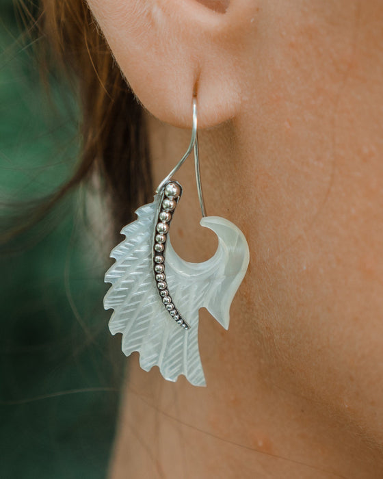 Exquisite Angel Wings earrings, crafted from lustrous mother-of-pearl and detailed sterling silver, radiating aesthetic grace and ethereal charm