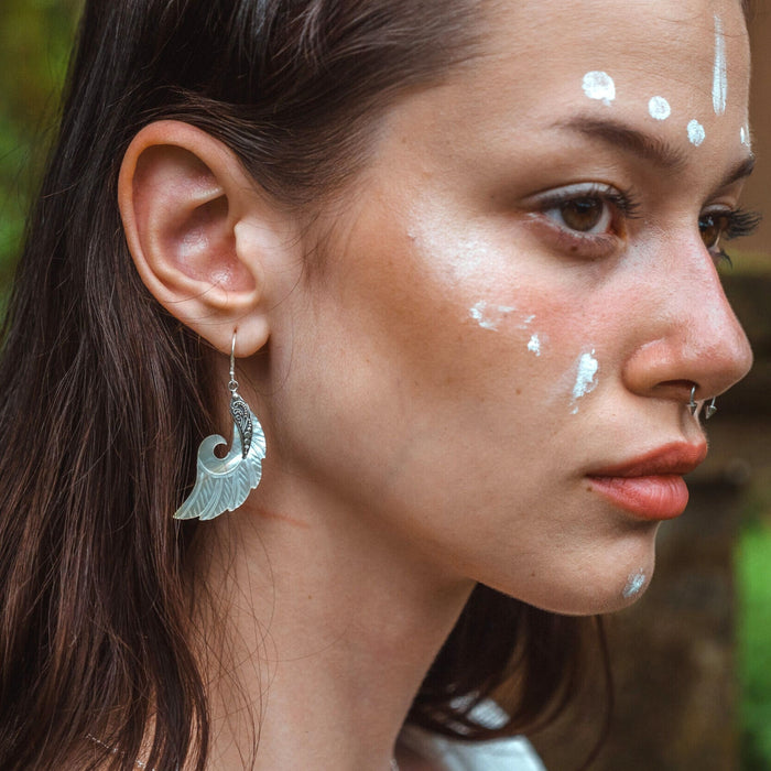 Exquisite Angel Wings earrings, crafted from lustrous mother-of-pearl and detailed sterling silver, radiating aesthetic grace and ethereal charm