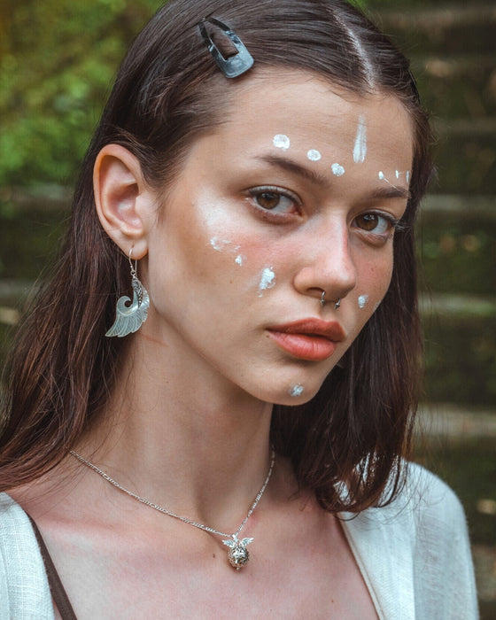Exquisite Angel Wings earrings, crafted from lustrous mother-of-pearl and detailed sterling silver, radiating aesthetic grace and ethereal charm