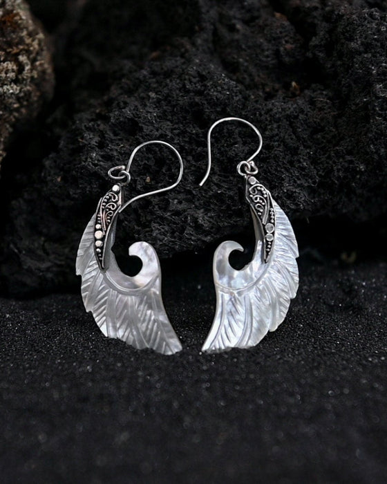 Exquisite Angel Wings earrings, crafted from lustrous mother-of-pearl and detailed sterling silver, radiating aesthetic grace and ethereal charm