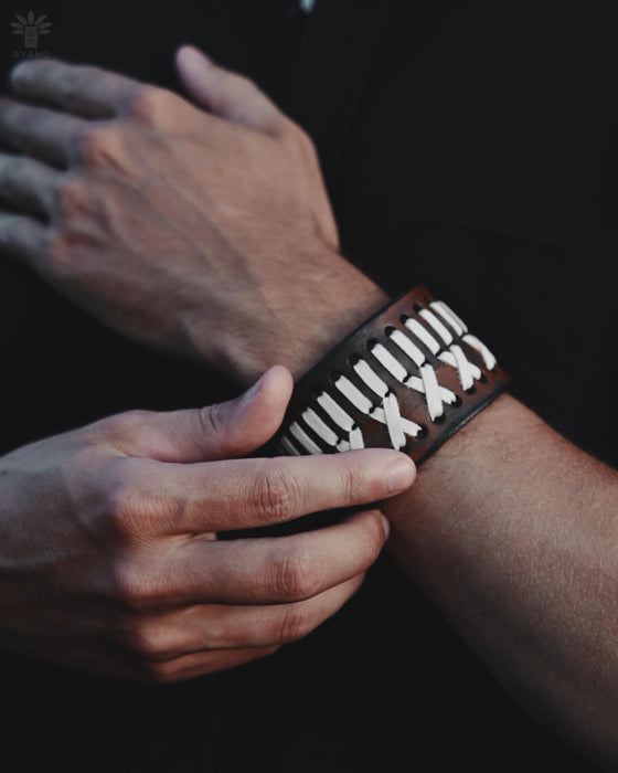 Bold, handcrafted buffalo leather bracelet with ethnic design, embodying raw strength and spiritual symbolism.