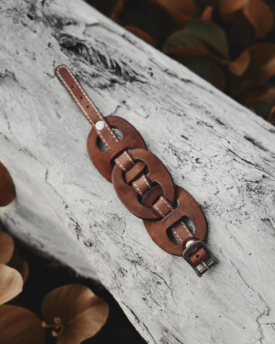 Men’s leather cuff with a triple-infinity design, carved by hand for a flexible, secure fit and powerful symbolism.