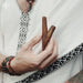 Hand holding two wooden sticks with a blurred background