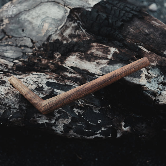 Wooden L-shaped tool on a textured dark surface