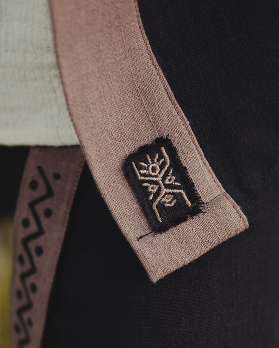 Close-up of a brown belt with a logo on a black garment, featuring the AYAGO brand.