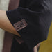 Close-up of a dark fabric with an embroidered logo on a blurred background