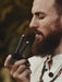 Man with a beard holding a walkie-talkie with a blurred natural background