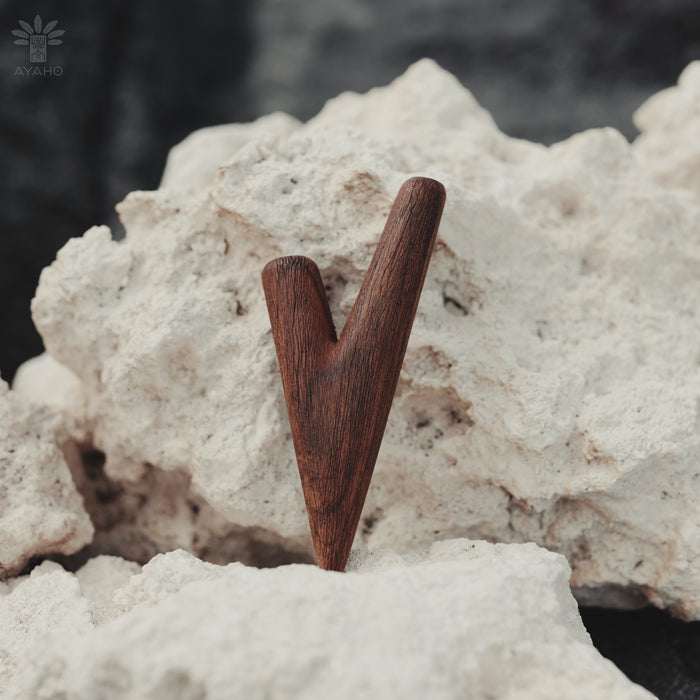 Wooden V-shaped object on a textured white surface