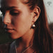 Close-up of a woman wearing gold earrings with a blurred background
