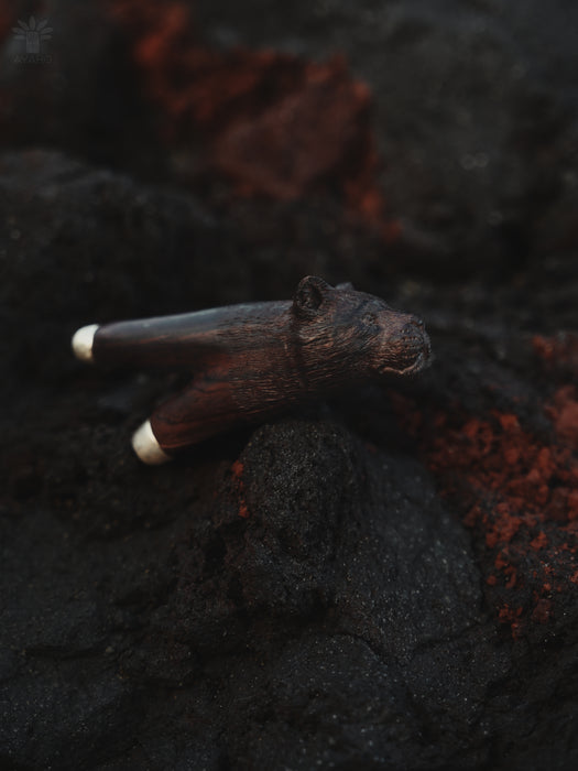 Wooden object with metallic accents on a textured dark surface