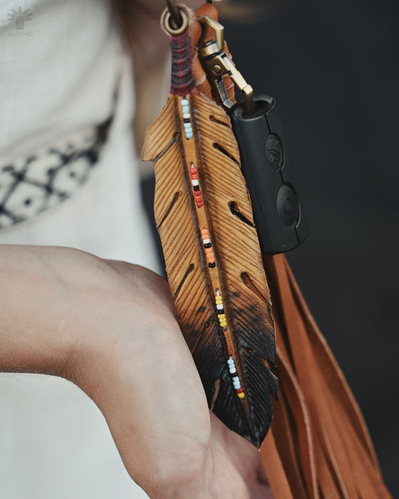 Tiny preserved owl feather in a glass vial pendant, attached to a braided leather necklace for everyday spiritual protection.