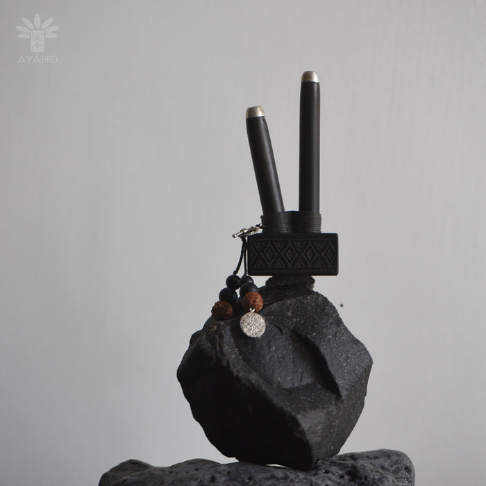 Black electronic device on a gray rock with a gray background