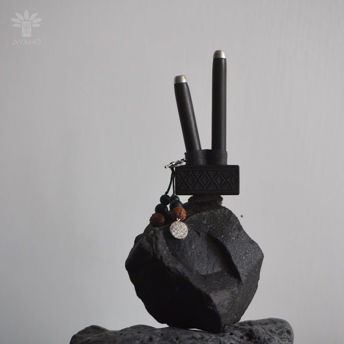 Black electronic device on a gray rock with a gray background
