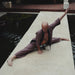 Man in a yoga pose on a stone platform by a pool