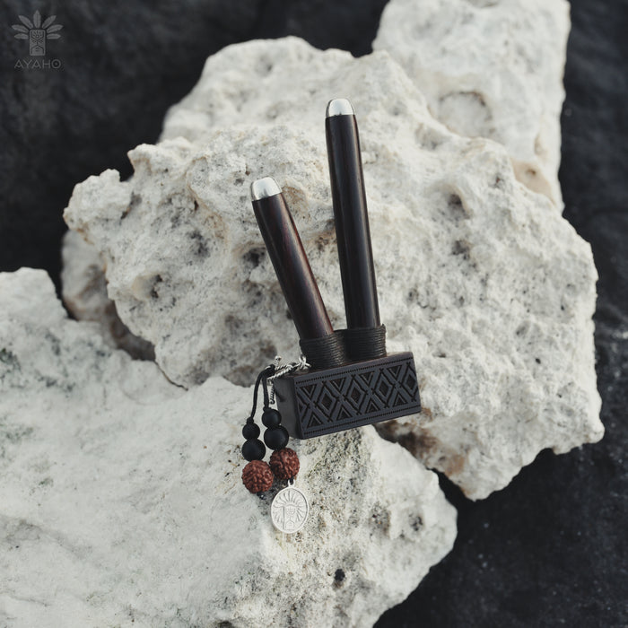 Black and silver tool with decorative elements on a textured rock surface
