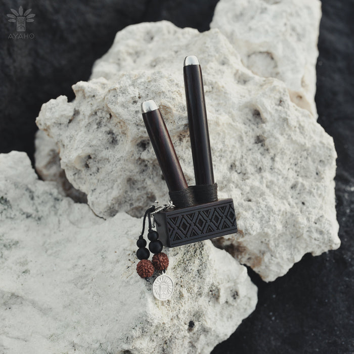 Black and silver tool with decorative elements on a textured rock surface