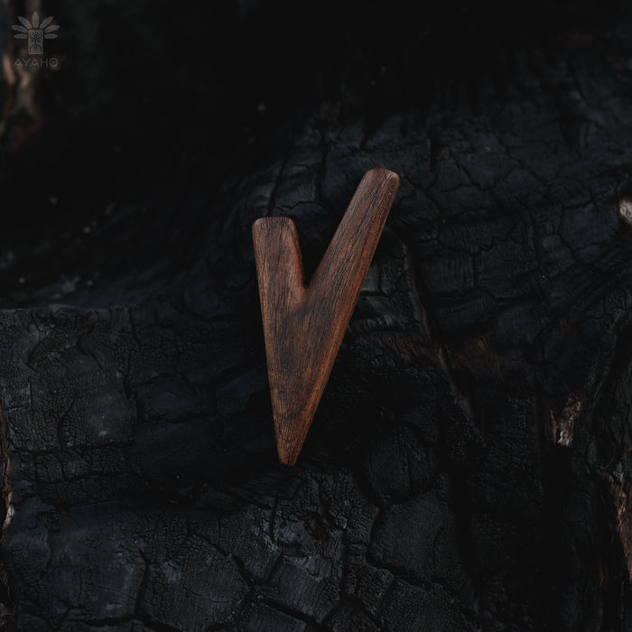 Wooden arrowhead on a dark, textured surface