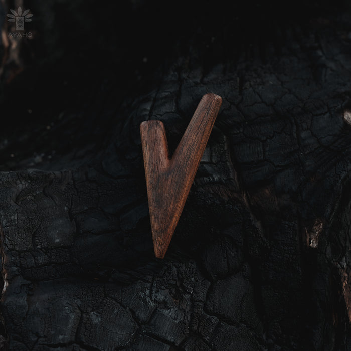 Wooden arrowhead on a dark, textured surface
