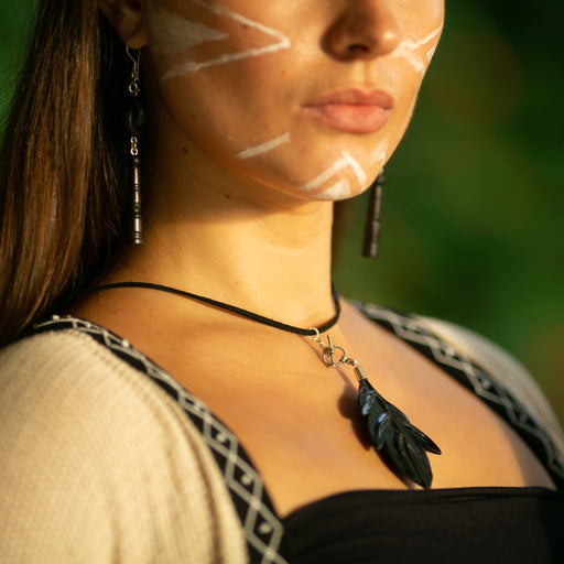 Woman adorned with a black kyanite bead necklace, a spiritual talisman for energy protection, and Rudraksha bead earrings, symbolizing shamanic tradition.