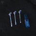 Three silver hair sticks with horse designs and a blue bottle labeled 'Nukini' on a dark background.