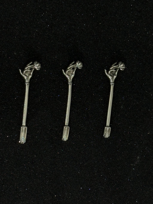 Three metallic hair accessories with decorative elements on a black background