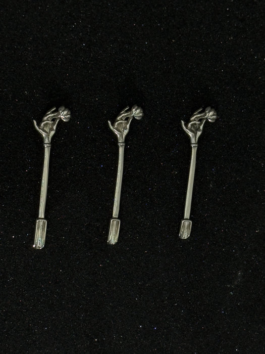 Three metallic hair accessories with decorative elements on a black background