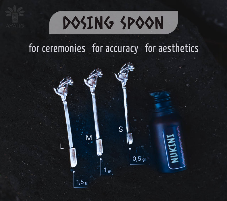 Dosing spoons with measurements and a bottle labeled 'INKI' on a dark background