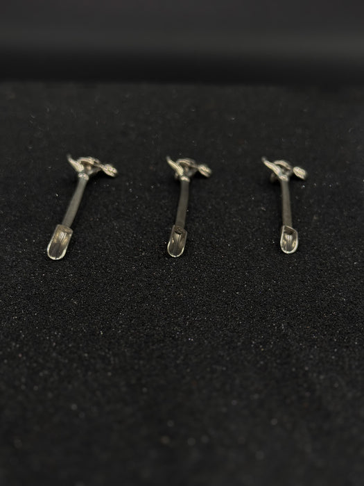 Three small metal objects on a black textured surface