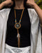 Close-up of a traditional-style dream catcher amulet with amethyst and howlite beadsx, hanging from a car mirror.