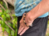 Person wearing a beaded bracelet with a natural background