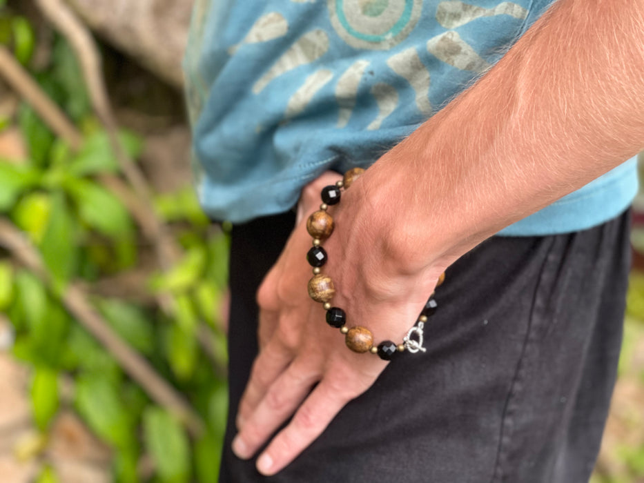 Person wearing a beaded bracelet with a natural background