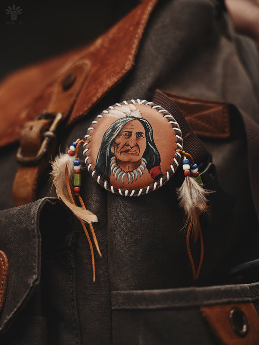 Versatile feather brooch with a sturdy clasp, styled on a floppy sunhat and denim tote bag for boho flair.