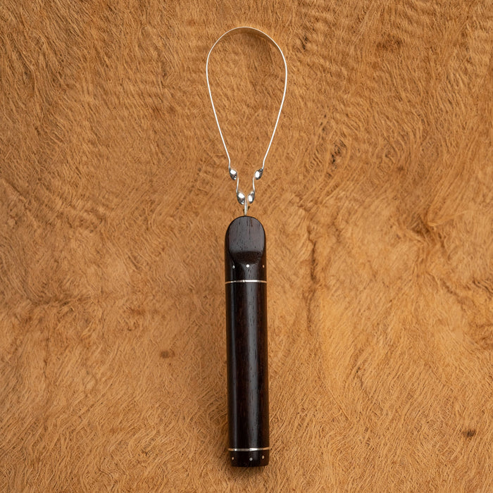 Hand-polished copper tongue cleaner with antimicrobial properties, resting on bamboo tray with fresh mint leaves.