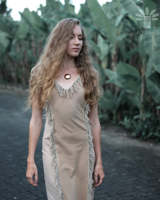 A woman gracefully descends steps in a handmade boho maxi dress with fringe detailing, perfect for bohemian festivals or a boho wedding, embodying a romantic and ethereal goddess vibe