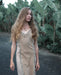 A woman gracefully descends steps in a handmade boho maxi dress with fringe detailing, perfect for bohemian festivals or a boho wedding, embodying a romantic and ethereal goddess vibe