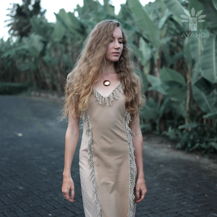 A woman gracefully descends steps in a handmade boho maxi dress with fringe detailing, perfect for bohemian festivals or a boho wedding, embodying a romantic and ethereal goddess vibe