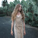 A woman gracefully descends steps in a handmade boho maxi dress with fringe detailing, perfect for bohemian festivals or a boho wedding, embodying a romantic and ethereal goddess vibe