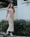 A woman gracefully descends steps in a handmade boho maxi dress with fringe detailing, perfect for bohemian festivals or a boho wedding, embodying a romantic and ethereal goddess vibe