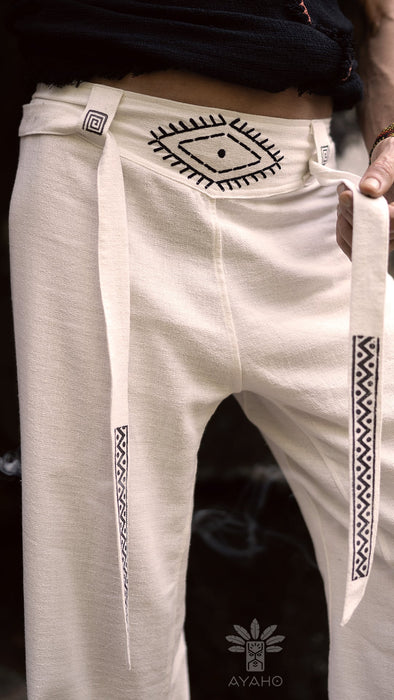 White pants with black geometric patterns and 'AYAHO' branding on a dark background