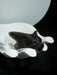 Black panther figurine on a white pedestal against a dark background