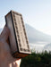Wooden box with laser engraved pattern held by a hand against a mountainous background