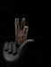 Decorative object shaped like a hand holding a stylized cigarette on a black background
